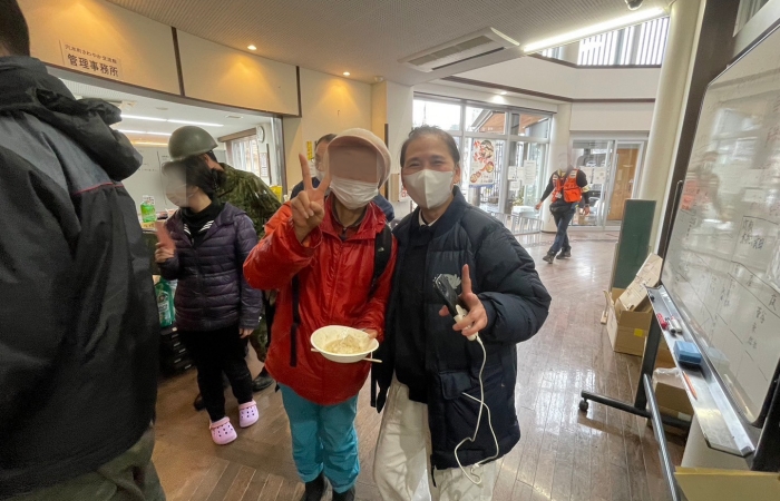 有田女士和慈濟志工經過一番交談後,她重拾了笑容,合照時還會開心比YA。(圖:慈濟基金會)