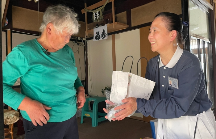 志工手上收下的那一大袋零錢,是廣田阿嬤一點一滴存下來的愛心,她也要加入慈濟施善的行列。(攝影:楊景卉)