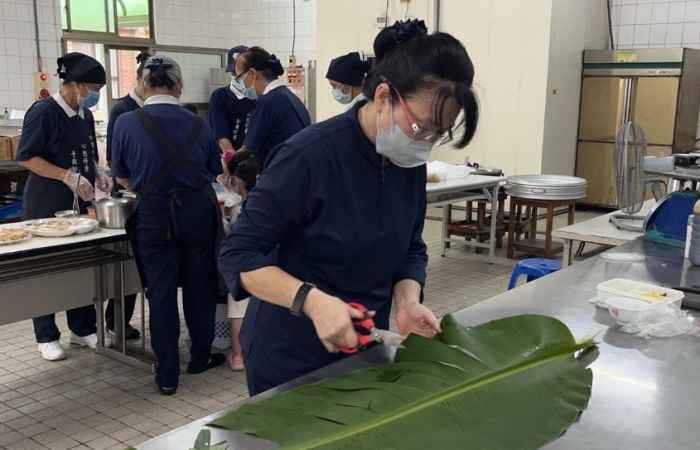 一口蔬,講求環保,且要讓跑者方便取用,志工摘來香蕉葉洗乾淨,賴沛綾師姊幫忙裁剪當容器。(攝影者:廖麗玉,地點:雲林聯絡處)