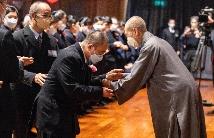 圖說:2023年12月25日,桃園區第2場授證暨歲末祝福,在桃園靜思堂舉行,靜思精舍德勱師父為陳佳銘戴上手佛珠。(攝影:丘亭)