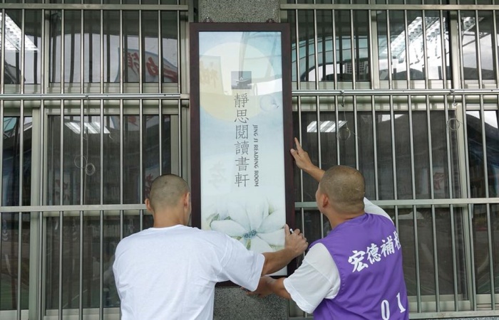 圖說:靜思書軒同仁與慈濟志工進行內部布置工作,受刑人協助掛牌。(攝影:李昭田)