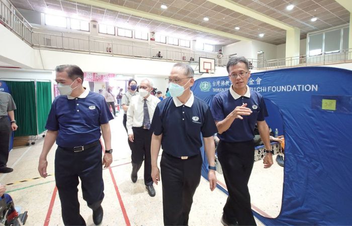 慈濟基金會執行長顏博文(前中)、副執行長張濟舵(白襯衫)、副執行長何日生(左)至中華國小關懷來避難的居民。(攝影:徐政裕)